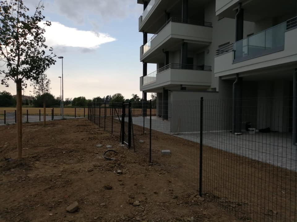 Condominio protetto da recinzione modulare a maglia elettrosaldata fissata su paletti robusti. L'installazione di questa recinzione che delimita il giardino del condominio dal suolo pubblico, è una recinzione a maglia elettrosaldata modulare